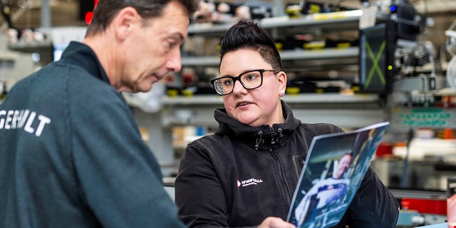 Therese Cedin, försäkringsinformatör, håller upp en broschyr och samtalar med en medlem