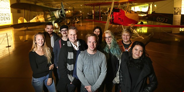 En grupp personer framför gamla flygplan.
