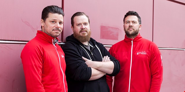 Robin Paulrud i rött, Oscar Brandin i svart och Karl Lewenhagen i rött vid en röd vägg.