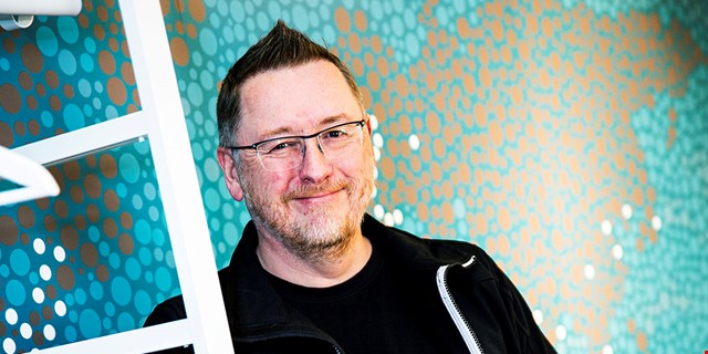 Michael Lönn, förtroendevald i IF Metall, framför en blåspräcklig tapet.
