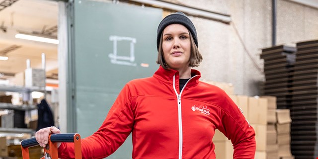 Martina Gahlin, förtroendevald i IF Metall, i röda profilkläder på sin arbetsplats.