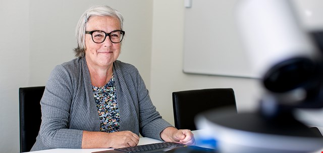 Porträtt av Marie-Louise Larsson, sittande, förtroendevald i IF Metall, i blommig blus och grå kofta, i ABF:s studio för digitala utbildningar med studioutrustning i förgrunden.