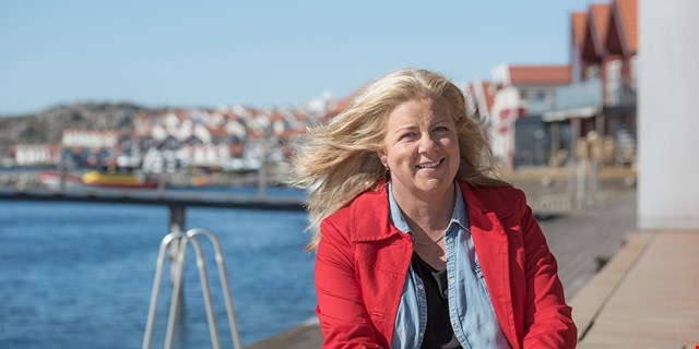 Person i röd jacka i skärgårdsmiljö.