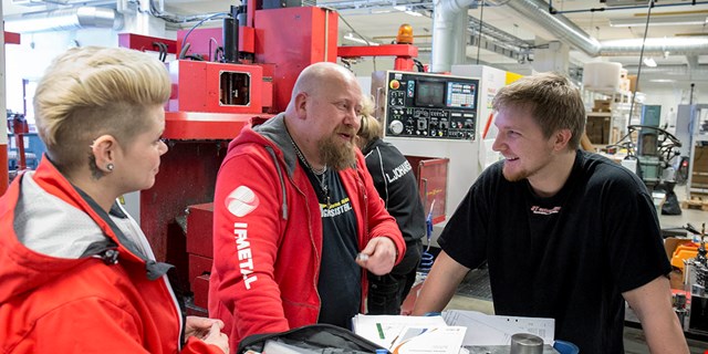 Tre personer samtalar med varandra. Robert står i mitten på bilden.