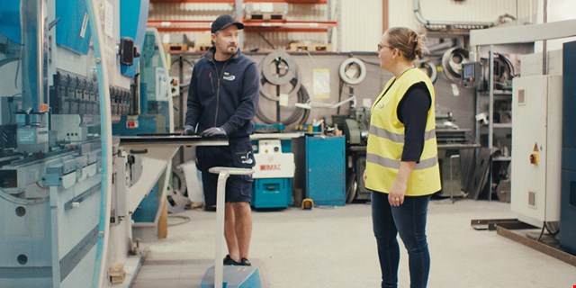 Bilden visar två anställda på Prevent som samtalar med varandra.